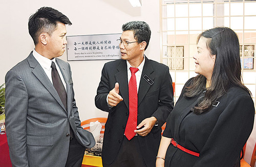張盛聞(左)在會議后,,繼續(xù)聆聽與會者的意見。