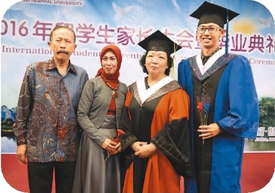 6月23日,,參加廣西師范大學(xué)畢業(yè)典禮的留學(xué)生及家長與廣西師范大學(xué)黨委書記王枬(右二)合影。中新社記者