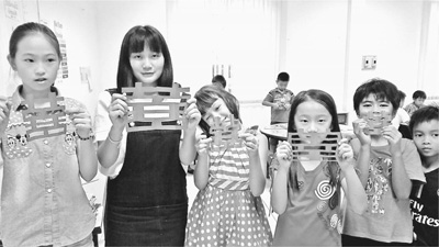 中國志愿者在老撾白云碧國際學(xué)校傳播中國文化,。圖為志愿者胡佳佳(左二)和學(xué)生們展示他們的剪紙作品。中國青年志愿者赴老撾服務(wù)隊(duì)供圖