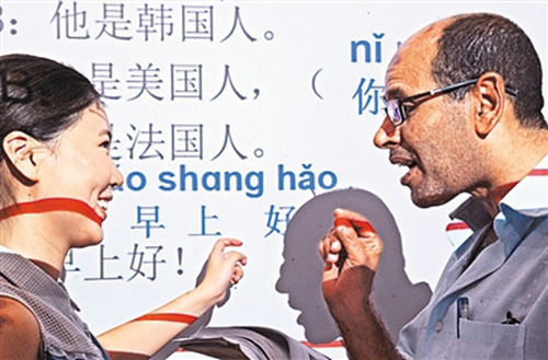 埃及客商埃勒賽義德(右)向老師學說“早上好”,。(新華社記者