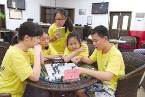 夏令營(yíng)的海外華裔學(xué)子學(xué)下漢字棋。(陳輝