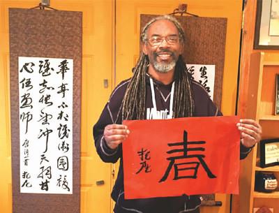 中國僑網(wǎng)圖為托尼在展示自己的書法作品,。 (屠新時)