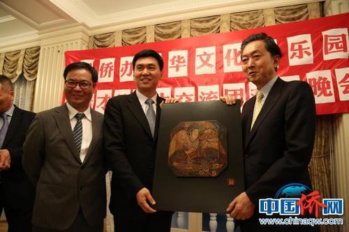 中國僑網圖為國務院僑辦文化司副司長王夢黎與鳩山由紀夫互換禮物。