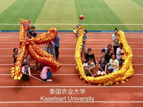 中國(guó)僑網(wǎng)舞龍課擺出泰國(guó)農(nóng)業(yè)大學(xué)英文簡(jiǎn)寫造型。
