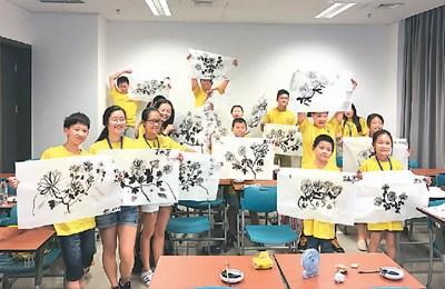 中國(guó)僑網(wǎng)中級(jí)五班的同學(xué)開(kāi)心地展示他們的國(guó)畫(huà)作品,。李雙傾攝