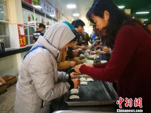 中國僑網(wǎng)資料圖:留學(xué)生在中國老師指導(dǎo)下包餃子,?!⊥蹑?攝