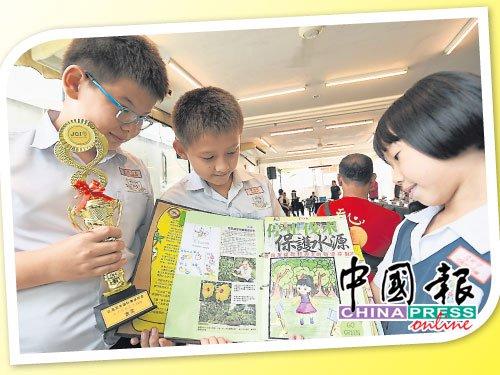 中國僑網(wǎng)文明小學(xué)組的亞歷山大(左起),、羅柏特及呂珂寧得獎(jiǎng)后,,展示他們的剪報(bào)作品。(馬來西亞《中國報(bào)》)