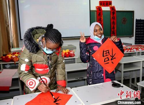 中國僑網(wǎng)圖為留學生展示其寫的“福”字 楊東 攝