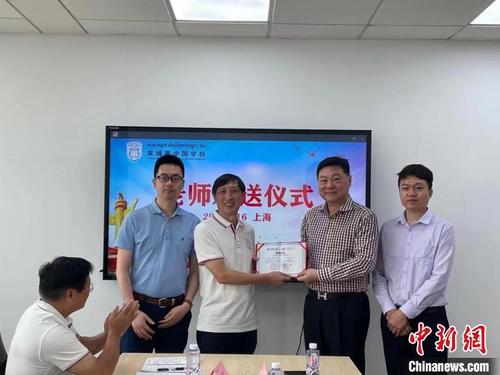 中國僑網(wǎng)高華(右二)為執(zhí)行校長陳自元(左二)頒發(fā)聘用證書。 柬埔寨中國學校供圖