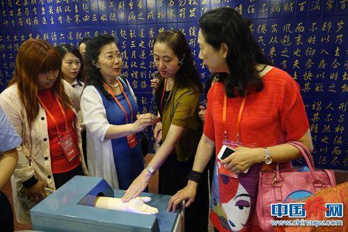 中國僑網(wǎng)50余家海外華文媒體代表參觀天津濱海高新區(qū),。大家在模擬脈搏儀器上“把脈”,。冉文娟 攝