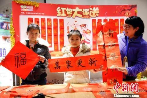中國(guó)僑網(wǎng)資料圖:游客用寫(xiě)春聯(lián)的方式迎接新年的來(lái)臨,?!珡┛?攝