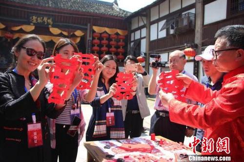 中國僑網(wǎng)圖為海外華文媒體高層在走馬古鎮(zhèn)體驗(yàn)剪紙藝術(shù)?!「邊纹G杏 攝
