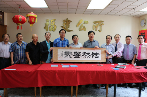福建省海外交流協(xié)會一行將帶來的禮物贈送給福建公所。(美國《僑報》/蘇夏竹