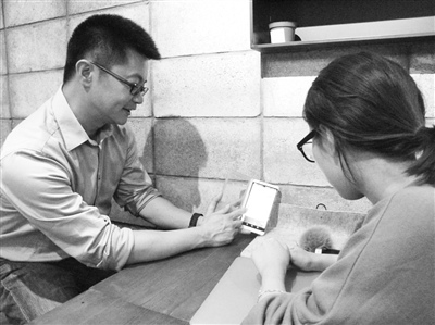在接受采訪時,談健用手機軟件演示無鑰簽名技術。成怡昕
