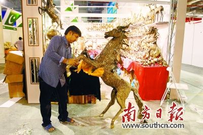 26日,海絲博覽會展館內(nèi),外國參展商正在加緊布置展位,。圖為緬甸參展商正在擦拭他們的展品,。