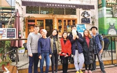 中國僑網唐雨冬(右三)在自己創(chuàng)立的首家旅行主題咖啡館前合影,。