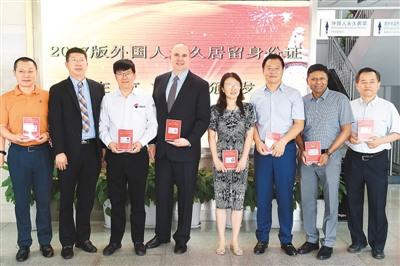 中國僑網(wǎng)6月16日,在北京市公安局出入境管理局中關(guān)村外國人服務(wù)大廳,,首批獲得2017版外國人永久居留身份證的外籍人士合影,。 新華社記者 鞠煥宗攝