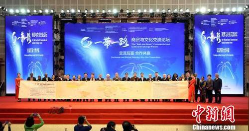 中國僑網中外代表共同展示十米長“一帶一路”商貿與文化交流論壇的羊皮紙長卷,?!『┌亍z