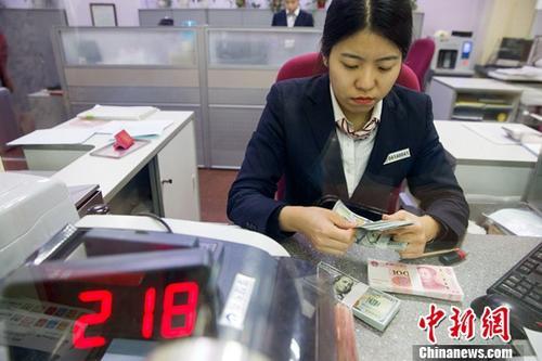 中國僑網(wǎng)資料圖 銀行工作人員清點(diǎn)貨幣,。中新社記者 張?jiān)?攝