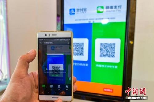 中國僑網資料圖:一名顧客在掃碼支付。(中新社記者 駱云飛 攝)