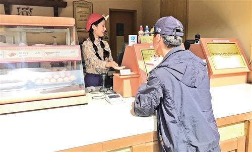 中國(guó)僑網(wǎng)韓國(guó)游樂場(chǎng)內(nèi)的小吃攤位都可選擇支付寶付款。本報(bào)記者 白云飛攝