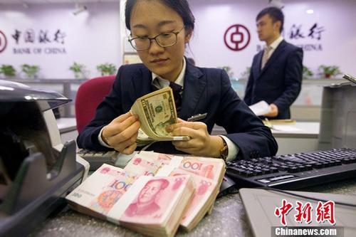 中國僑網資料圖:銀行工作人員正在清點貨幣,。中新社記者 張云 攝