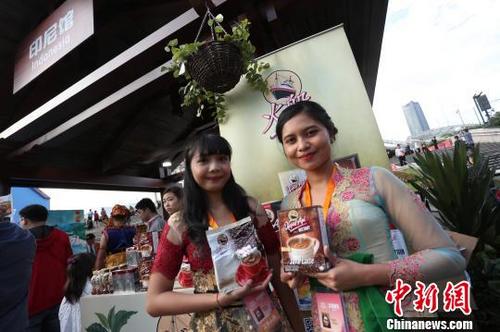中國僑網(wǎng)身穿傳統(tǒng)服飾的印尼女子,,為本國展示特色產(chǎn)品,。 張亨偉 攝
