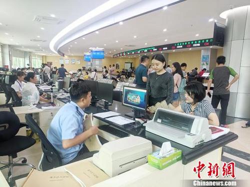 中國僑網圖為民眾在辦理引進人才落戶業(yè)務,?!×栝z