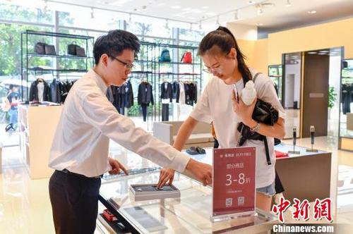 中國僑網(wǎng)圖為消費(fèi)者在??谌赵聫V場(chǎng)免稅店購物?!●樤骑w 攝