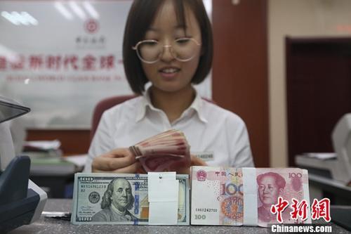 中國僑網資料圖:一銀行工作人員正在清點貨幣。(中新社記者 張云/攝)