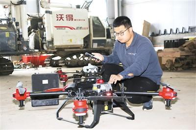 中國僑網(wǎng)丁旦正在手機(jī)上調(diào)試無人機(jī),。(圖片來源:《人民日報(bào)海外版》)