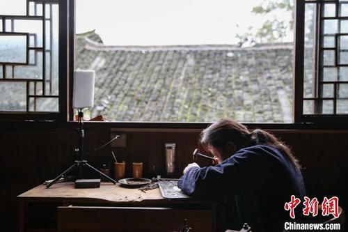 中國(guó)僑網(wǎng)10月10日,銀匠潘仕學(xué)在麻料村制作銀飾配件,?!■暮陚悺z