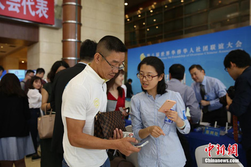 “僑寶”客戶端工作人員向僑領介紹客戶端有關情況,。