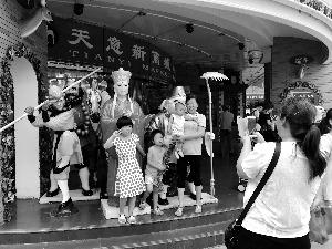 中國僑網(wǎng)天意市場閉市進(jìn)入倒計時,,顧客與門口的塑像合影。北京晨報記者 王巍/攝