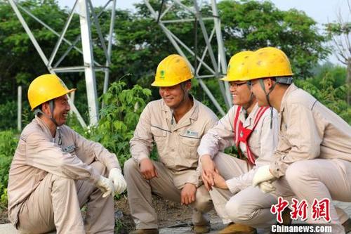 中國(guó)僑網(wǎng)許啟金和徒弟們一起探討工作,?!№n蘇原 攝
