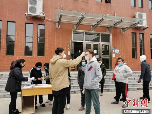 中國僑網(wǎng)湖南工業(yè)大學(xué)工作人員為留學(xué)生測量體溫,?!£惽邸z