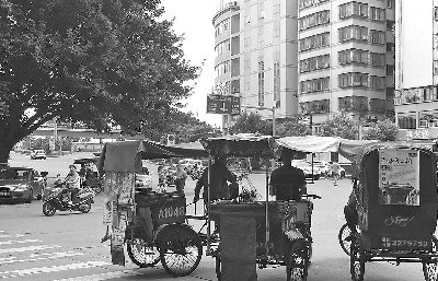 幾輛三輪車停靠在路口,阻塞交通,。