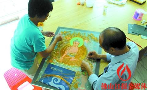 馮錫華(右)認(rèn)真制作掐絲琺瑯,。