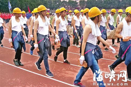 62名新生手持磚塊,、水泥袋,、鏟子等走方陣
