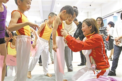 圖為江鈺源跪著為學(xué)弟,、學(xué)妹們簽名,。