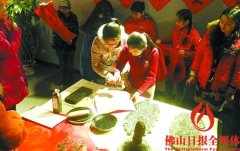 中國(guó)僑網(wǎng)北京半步橋小學(xué)的學(xué)生體驗(yàn)印制木版年畫。/通訊員郭文鈉供圖