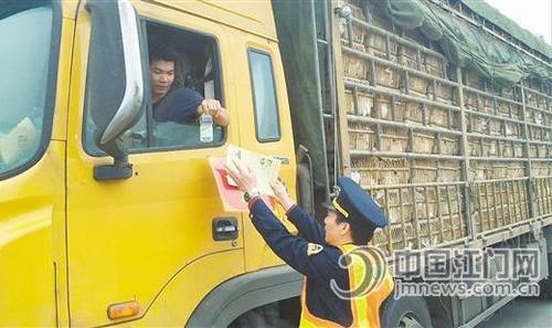 中國(guó)僑網(wǎng)工作人員向車(chē)輛駕駛員送上宣傳單,、“?!弊值任锲?。