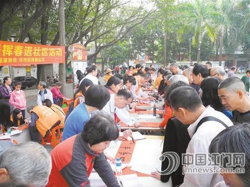 中國僑網(wǎng)文化志愿者們正在認真書寫對聯(lián),。