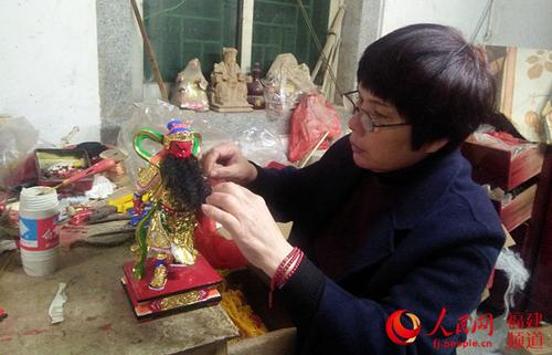 中國(guó)僑網(wǎng)洪碧虹正在為即將完工的佛像栽胡須,。