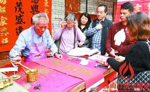 中國僑網(wǎng)年前,在快子路朱伯(左1)的揮春檔,,不少慕名前來的群眾在等候朱伯寫出心水的春聯(lián),。如今,由于安全等原因,,位于快子路的“揮春街”又面臨搬遷,。/佛山日報記者甘建華攝