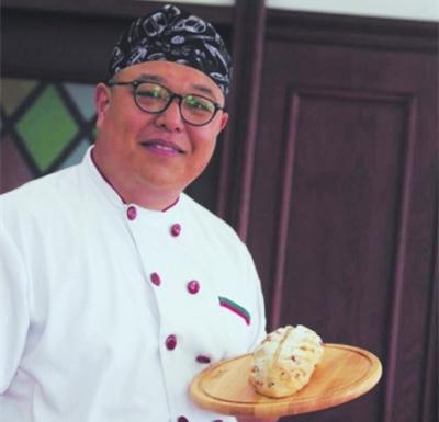 中國(guó)僑網(wǎng)鄧宇鈞在展示做好的面包,。(資料圖片)