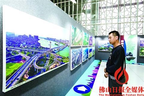 中國(guó)僑網(wǎng)一位市民駐足觀看航拍照片,。/佛山日?qǐng)?bào)記者 王澍攝