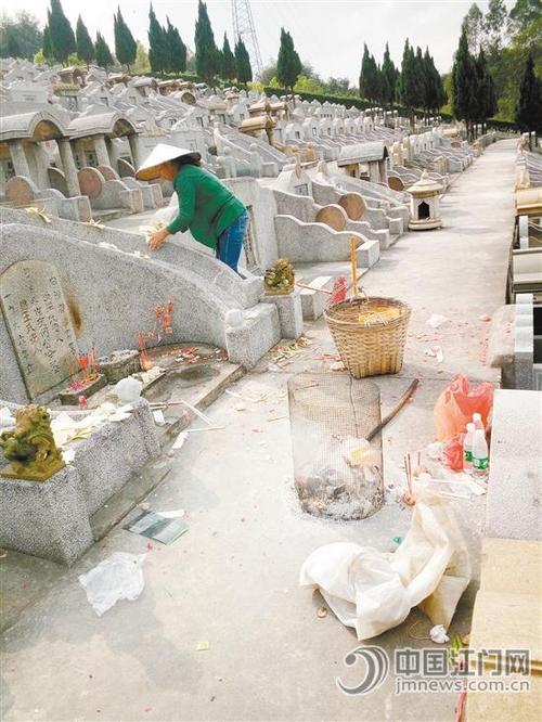 中國僑網(wǎng)江門長青墓園的保潔員忙著清理祭祀垃圾。
