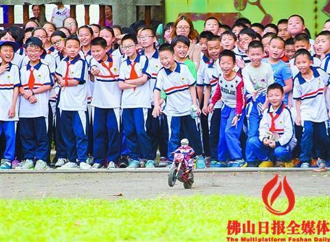 中國僑網(wǎng)昨日,南海區(qū)大瀝河東小學,,同學們在觀看遙控摩托車表演,。/佛山日報記者周春攝