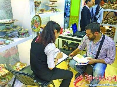 中國僑網(wǎng)圖為潮州市參展企業(yè)營銷人員與國外采購商開展訂單洽談,。 本報記者 曾曉純 楊燕芳 攝